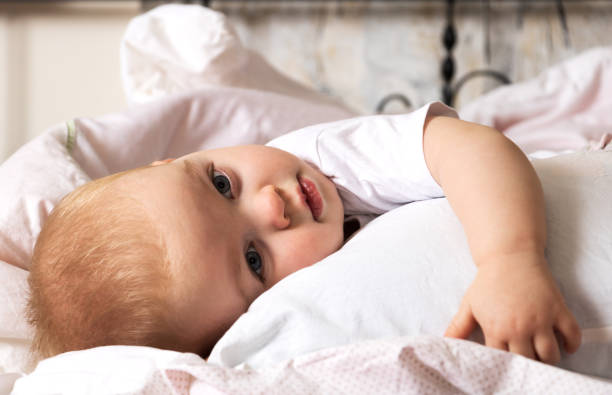 istock Preparing for bed, cute tired child lying on the bed hugging a pillow 1133354663