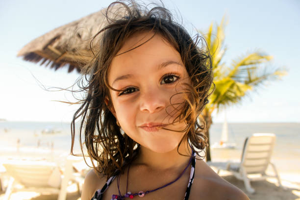 Little girl making a funny face at the beach in Cabo de Santo Agostinho, Pernambuco, Brazil.