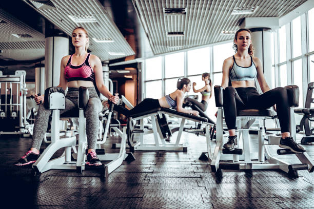 istock Four women in gym doing strength training on the simulator 1133358656