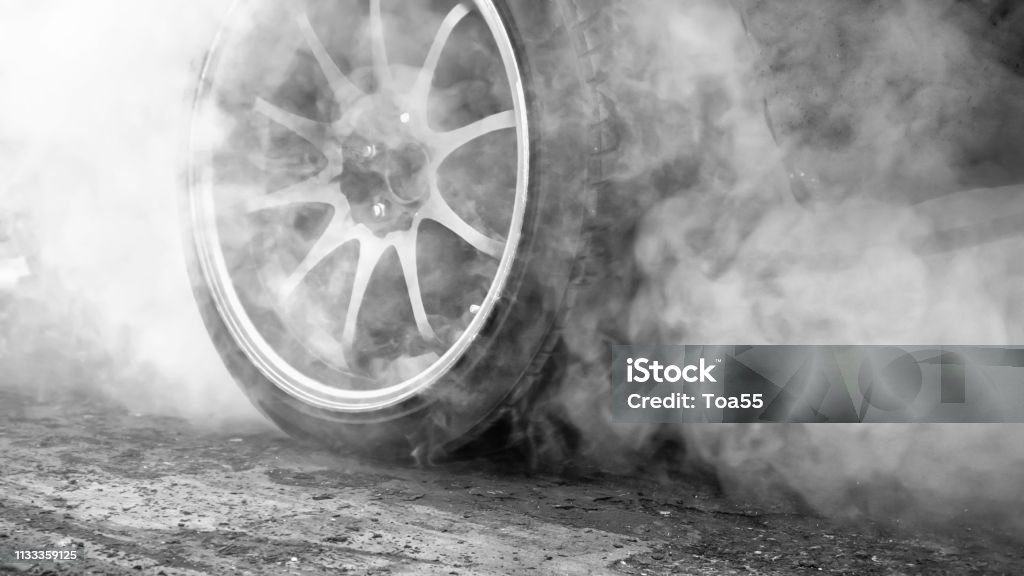 Drag racing car burns rubber off its tires in preparation for the race Tire - Vehicle Part Stock Photo