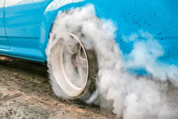 Drag racing car burns rubber off its tires in preparation for the race