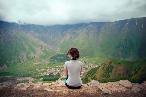 Traveling sits on the mountainside with a beautiful view of the mountains. Georgia. Kazbegi