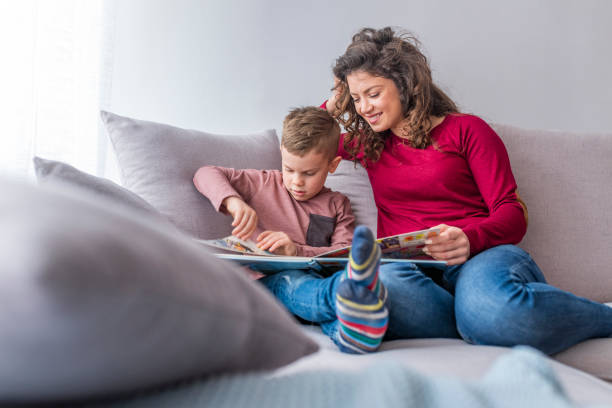 istock Young woman and her little son reading book 1133359998
