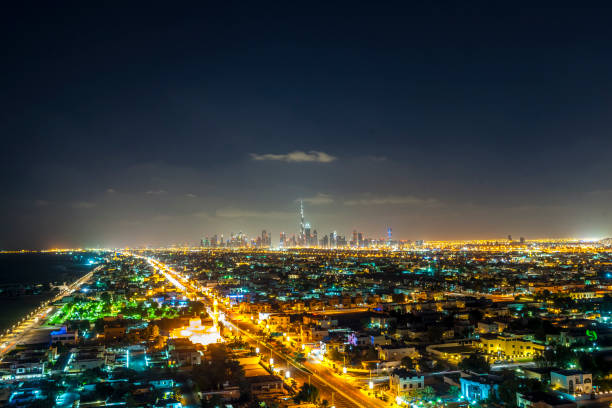 view from Jumeirah Beach Hotel on illuminated skyline of Dubai Downtown at night with Burj Khalifa