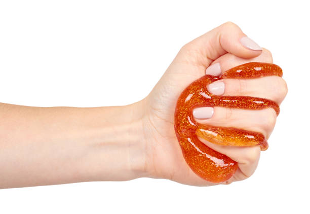 istock kid playing orange slime with hand, transparent toy 1133360982