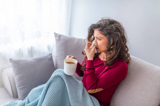 istock Young girl sick in bed with temperature drinks hot 1133361245