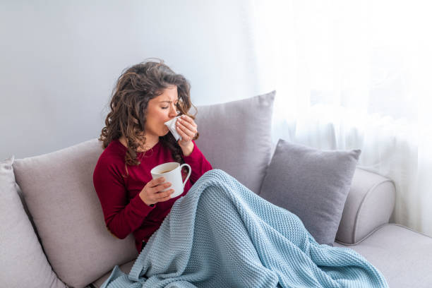 istock Sick woman with headache sitting under the blanket. 1133361286