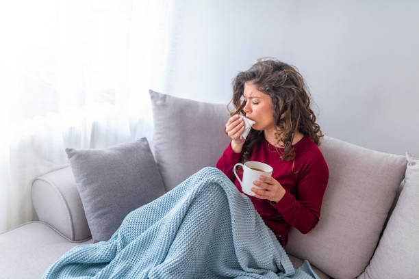 istock Sick woman with headache sitting under the blanket. 1133361454
