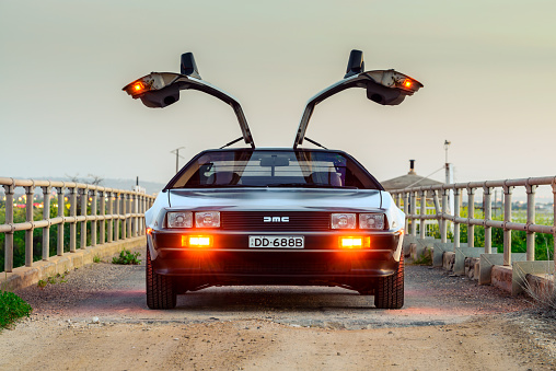 Adelaide, Australia - September 7, 2013: DeLorean DMC-12 car with opened gullwing doors parked on the bridge at dusk