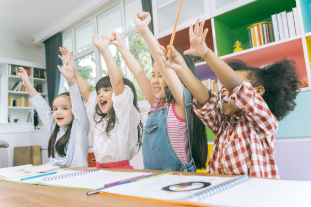 istock Group of little preschool kids hands up in class 1133363620