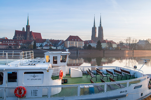 Wratislavia Floating Restaurant in Wrocław with Cathedral of St. John the Baptist twin towers, Poland