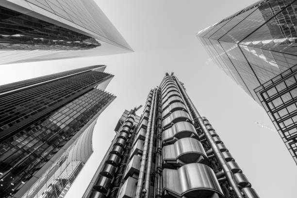 Looking directly up at the skyline of the financial district in central London, Lloyds of London, Cheese grater, Leadenhall Building, Willis towers Watson, the Scalpel - black and whitre stock image. Highly detailed abstract wide view up towards the sky from extremely low angle in the financial district of London City and its ultra modern contemporary buildings, including: Willis towers Watson, the Cheese grater, the Scalpel building on Lime street and the Lloyds building originally built in 1928 (design by R. Rogers), demolished and reconstructed and opened by Queen Elizabeth II in 1986. 
 London is the world's greatest foreign exchange market in the district. 
 Shot on Canon EOS R with 14mm wide angle prime lens. Monochrome edit in Black and White, image is ideal for background with high contrast. 122 leadenhall street photos stock pictures, royalty-free photos & images