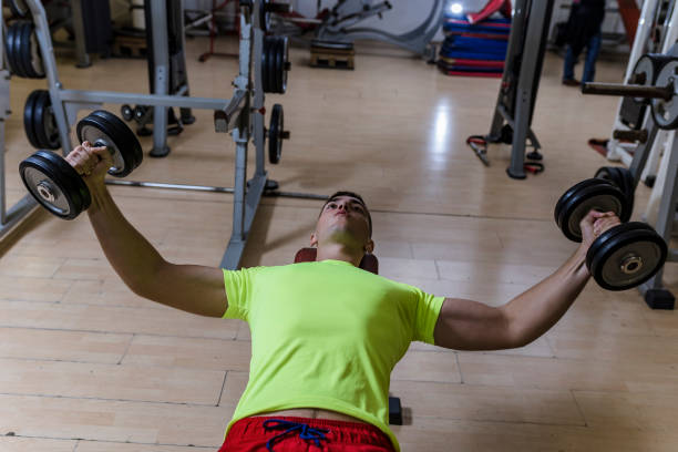 istock Young Bodybuilder is Exercising with Weights in The Gym 1133366591