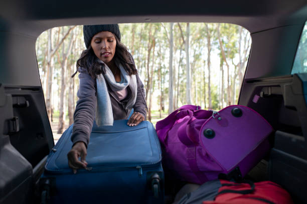 istock Woman loading bags into car trunk. 1133366845
