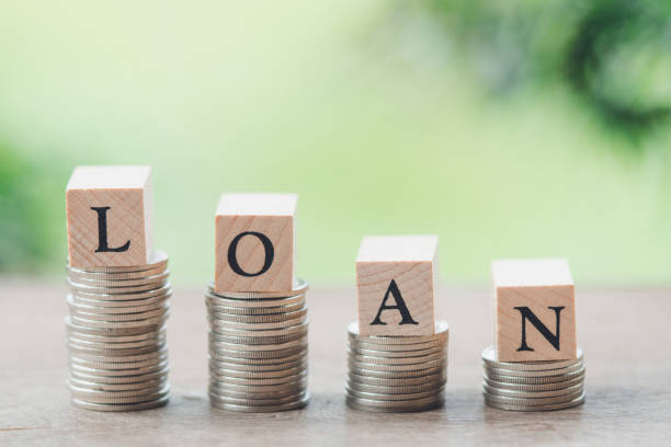 istock wood word LOAN and stack of coins to thinking and planning. using as background Money, Financial, Business Growth concept with copy space. 1133367697