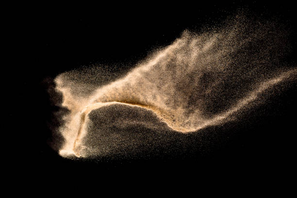 istock Dry river sand explosion. Brown color sand splash against black background. Yellow sand fly wave in the air. 1133368399