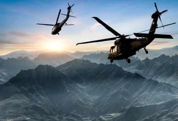 Military Helicopters flying against sunset stock photo