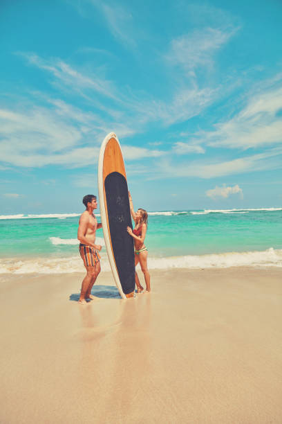istock Couple with surfboard enjoying on the tropical beach. 1133371471