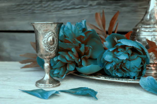 Metal vessel and blue peonies. Decorative composition.