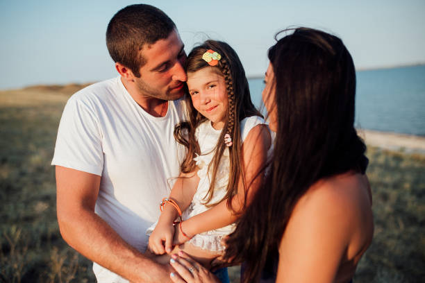 istock Young happy family walking along the seashore 1133372958