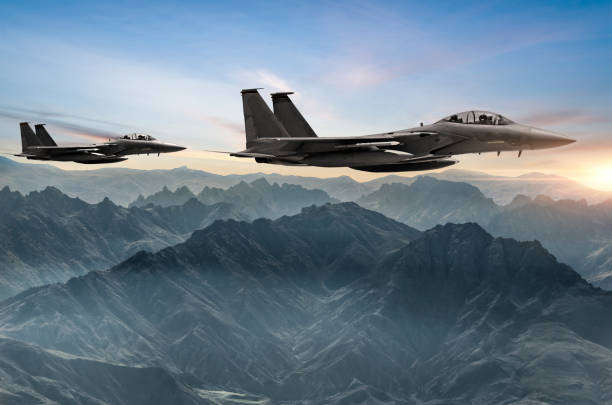 aviones figher volando sobre las montañas neblina al atardecer - defense industry fotografías e imágenes de stock