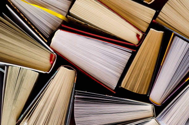 istock Lots of colourful thick open books stand on a dark background 1133374904
