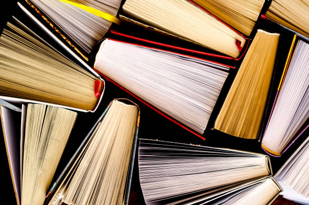 istock Lots of colourful thick open books stand on a dark background 1133374906