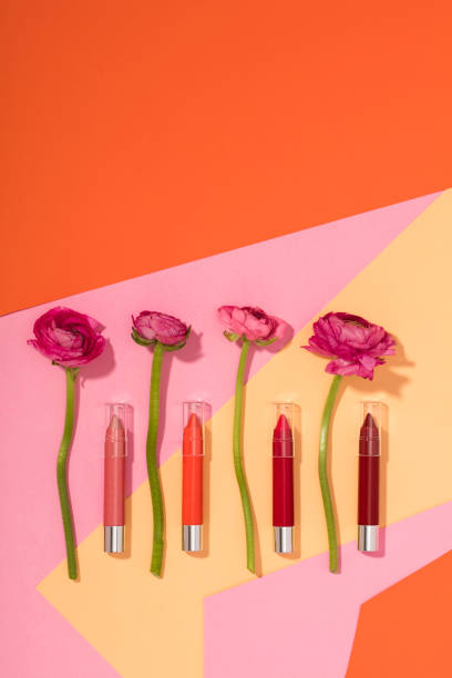 Lipstick pencils with flowers isolated on multi colored background