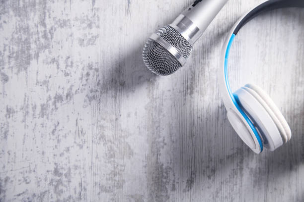 istock Microphone and headphones on a white desk. Top View 1133377317