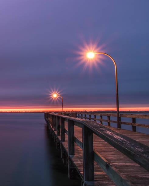 istock A fishing pier during dusk lit up by lamp posts. 1133377418