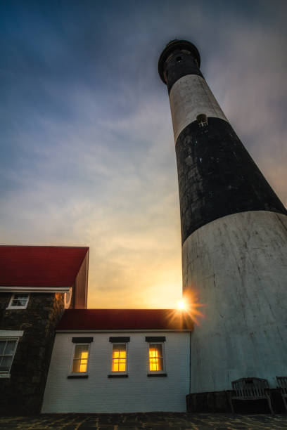 istock The sun setting behind a lighthouse as golden light shines through its windows. 1133377740