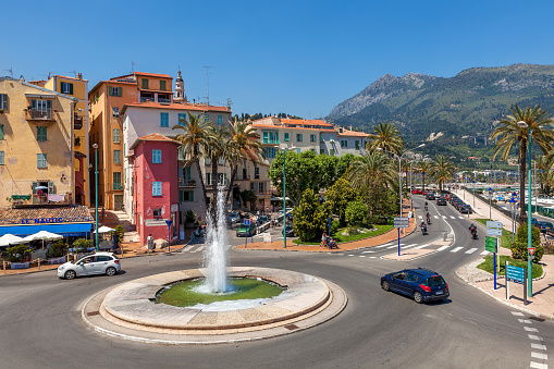 MENTON, FRANCE - JUNE 13, 2013: Roundabout with fountain in Menton - small town situated on French Riviera on Mediterranean sea. It is popular touristic resort and famous for its gardens.