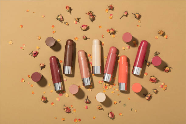 Lip balms with rose petals isolated on brown background
