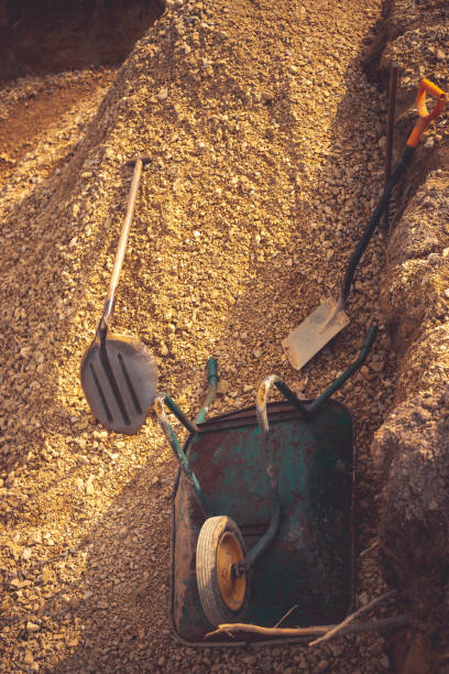 zasypywanie wykopu pod płytą fundamentu. konstrukcja, dolomit, łopaty i taczki. - scaffolding wheel construction site metal zdjęcia i obrazy z banku zdjęć