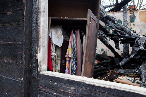 Rescued wardrobe with clothes in old burnt house