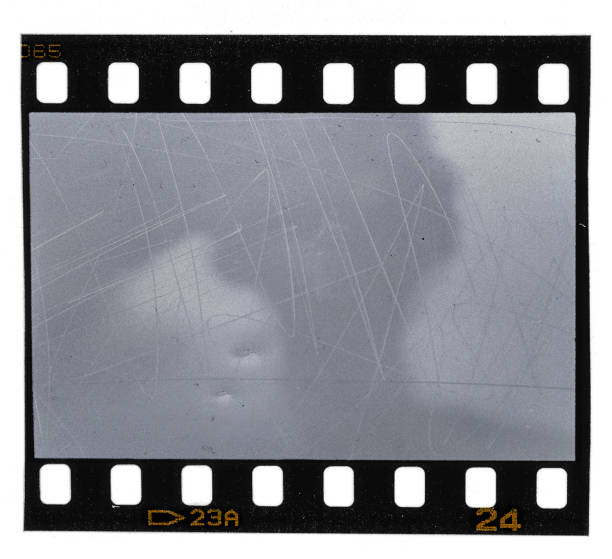 old and scratched 35mm movie film strip on white scratched 35mm filmstrip on white background 16mm film motion picture camera photos stock pictures, royalty-free photos & images