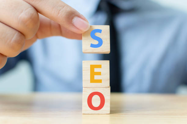 Search engine optimization concept. Hand putting wood block cube shape with word SEO
