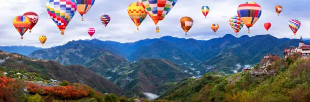 Colorful hot air balloon fly over panorama nature landscape of mountain view from Cingjing Farm, Nantou, Taiwan (Switzerland of Taiwan)