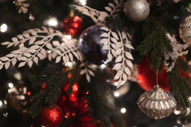 Merry Christmas and Happy New year Holidays! Decorating the Christmas tree indoors. Macro or close picture of xmas tree and gifts under it with red blue bulbs. Gift box background for 2019 gift card feliz navidad y felices fiestas de año nuevo! decorar el árbol de navidad en el interior. macro o imagen cercana de árbol de navidad y regalos debajo de ella con bombillas azules rojas. fondo de caja de regalo para 2019 tarjeta de regalo