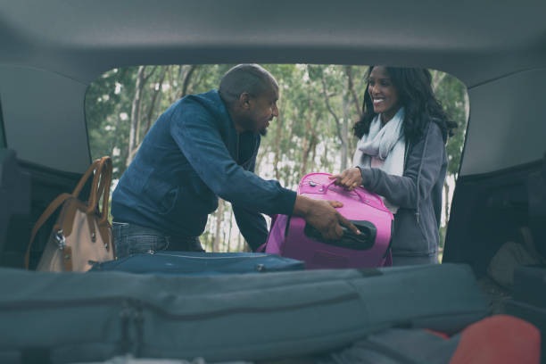 istock Couple loading together luggage into car trunk. 1133388579