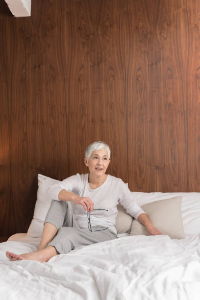 istock Mature woman sitting on a bed 1133389628