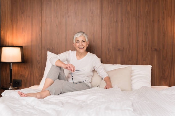 istock Mature woman sitting on a bed 1133389636