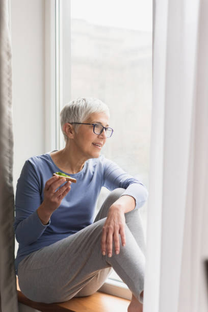 istock Mature woman looking through the window 1133389702