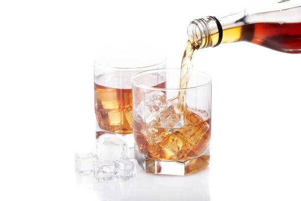 bottle of whisky and two glasses. pouring - action alcohol alcoholism bar imagens e fotografias de stock