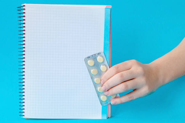 istock Hands holding pills and notebook on a blue background 1133390168