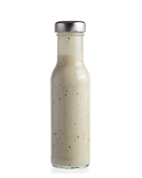 Salad dressing in bottle Salad dressing in glass bottle isolated on white background. salad dressing photos stock pictures, royalty-free photos & images