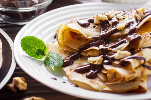 istock French crepes with chocolate sauce and walnuts in ceramic dish on wooden kitchen table 1133390355