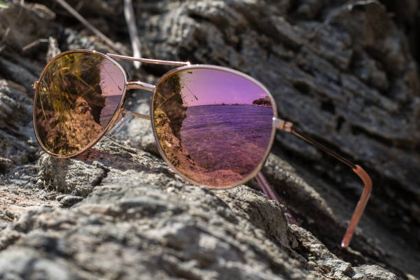 istock Sunglasses at the beach with sea reflection. 1133392485