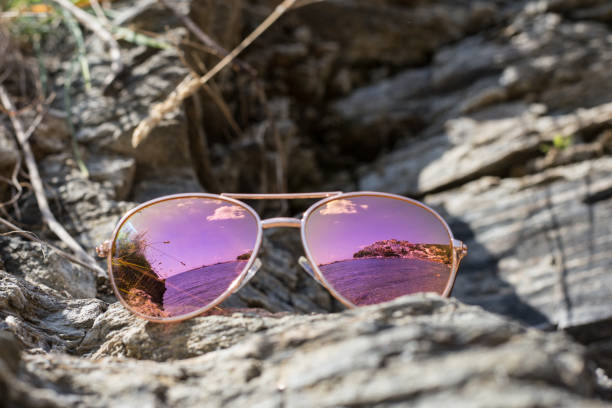 istock Sunglasses at the beach with sea reflection. 1133392496