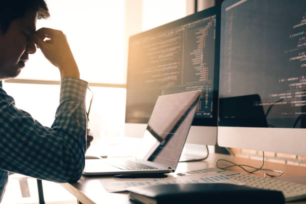 istock Man programmers are stressed and hand holding nose with headache at the office while working analyzing on desk in code at office room. 1133394277